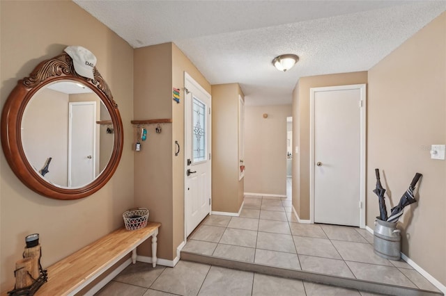 15005 Roundup Dr, Tampa, FL 33624 - foyer with a textured ceiling, light tile patterned flooring, and baseboards