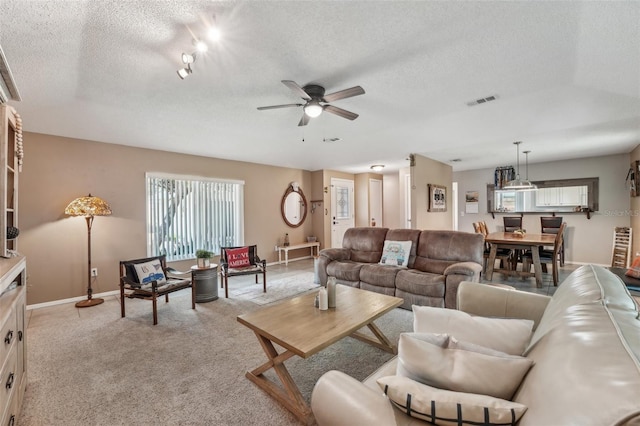 15005 Roundup Dr, Tampa, FL 33624 - living area featuring a ceiling fan, a textured ceiling, baseboards, and light colored carpet