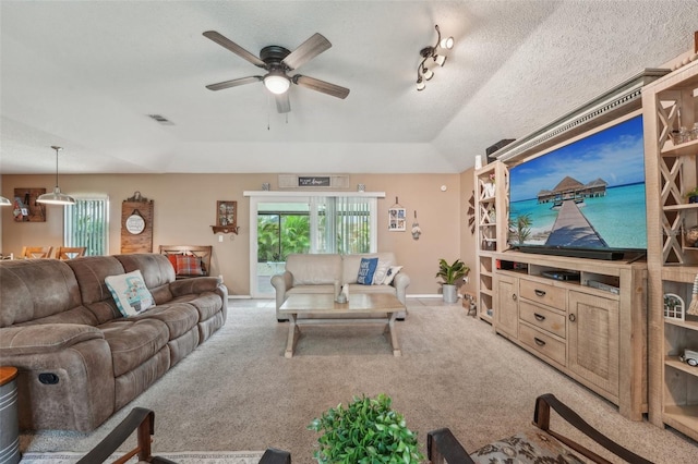 15005 Roundup Dr, Tampa, FL 33624 - living room featuring ceiling fan, plenty of natural light, light colored carpet, baseboards, and a textured ceiling