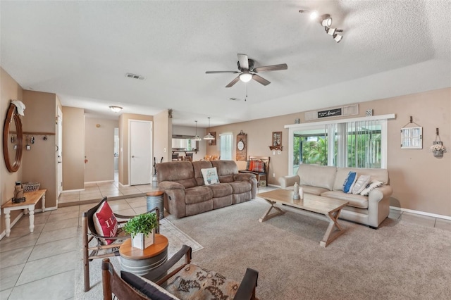 15005 Roundup Dr, Tampa, FL 33624 - living area featuring a ceiling fan, light tile patterned floors, baseboards, and a textured ceiling