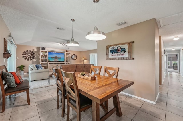 15005 Roundup Dr, Tampa, FL 33624 - dining space with a textured ceiling, light tile patterned floors, and baseboards