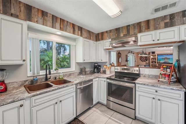 15005 Roundup Dr, Tampa, FL 33624 - kitchen featuring appliances with stainless steel finishes, range hood, a sink, a textured ceiling, and light countertops