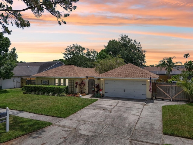 15005 Roundup Dr, Tampa, FL 33624 - ranch-style home with an attached garage, concrete driveway, a gate, and stucco siding