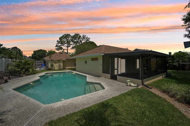 15005 Roundup Dr, Tampa, FL 33624 - pool at dusk featuring a sunroom and a patio area