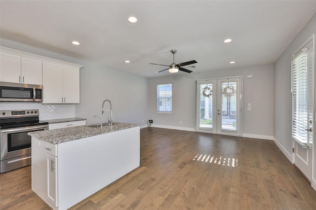 6619 S Manhattan Ave Unit 1, Tampa, FL 33616 - kitchen with stainless steel appliances, a sink, french doors, ceiling fan, and white cabinetry