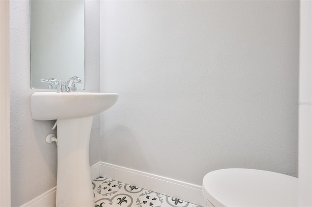 6619 S Manhattan Ave Unit 1, Tampa, FL 33616 - half bathroom with baseboards, toilet, and a sink