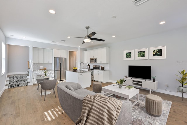 6619 S Manhattan Ave Unit 1, Tampa, FL 33616 - living area featuring a ceiling fan, baseboards, light wood finished floors, and recessed lighting