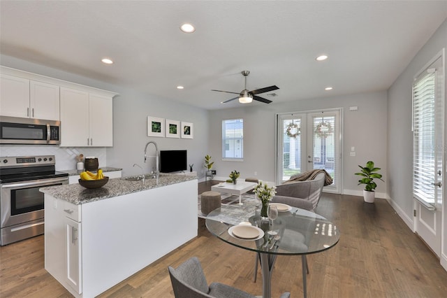 6619 S Manhattan Ave Unit 1, Tampa, FL 33616 - kitchen featuring stainless steel appliances, open floor plan, a sink, white cabinetry, and recessed lighting