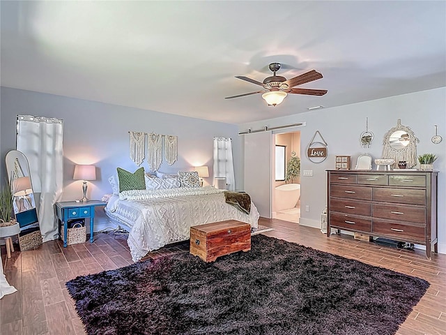 1014 Sylvia Ln, Tampa, FL 33613 - bedroom featuring wood tiled floors, a barn door, connected bathroom, and a ceiling fan