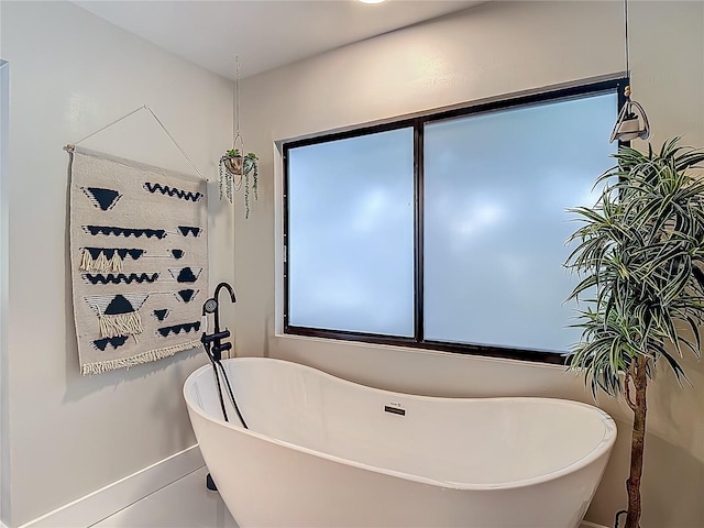 1014 Sylvia Ln, Tampa, FL 33613 - full bathroom featuring a soaking tub and baseboards