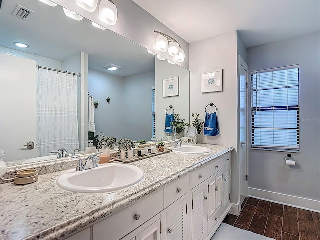 1014 Sylvia Ln, Tampa, FL 33613 - full bathroom featuring double vanity and wood finished floors