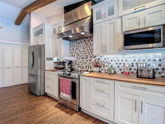 1014 Sylvia Ln, Tampa, FL 33613 - kitchen with appliances with stainless steel finishes, butcher block countertops, wall chimney range hood, tasteful backsplash, and dark wood-type flooring