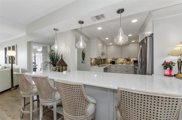 2700 Bayshore Blvd Unit 11405, Dunedin, FL 34698 - kitchen with freestanding refrigerator, a peninsula, tasteful backsplash, a sink, and light stone countertops
