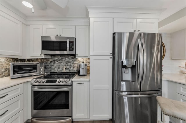 2700 Bayshore Blvd Unit 11405, Dunedin, FL 34698 - kitchen with stainless steel appliances, backsplash, light countertops, white cabinetry, and ceiling fan