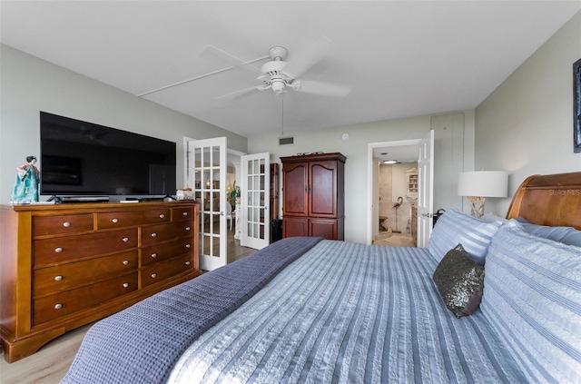 2700 Bayshore Blvd Unit 11405, Dunedin, FL 34698 - bedroom with french doors, wood finished floors, ceiling fan, and connected bathroom