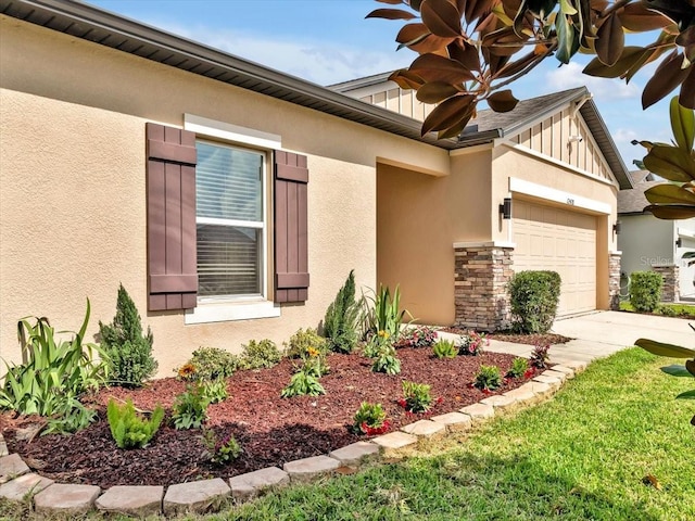 12428 Chaya Ct, Spring Hill, FL 34610 - view of front of home featuring an attached garage, concrete driveway, stone siding, board and batten siding, and stucco siding