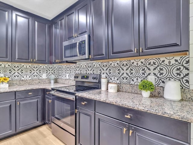 12428 Chaya Ct, Spring Hill, FL 34610 - kitchen featuring stainless steel appliances, tasteful backsplash, light stone countertops, and light wood-style floors