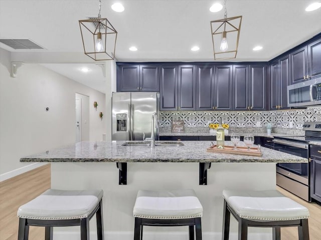 12428 Chaya Ct, Spring Hill, FL 34610 - kitchen with appliances with stainless steel finishes, a sink, light wood-type flooring, light stone countertops, and recessed lighting