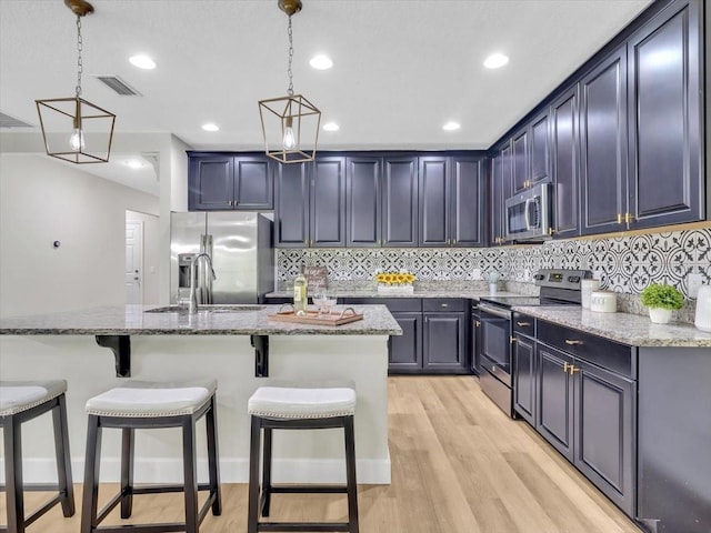 12428 Chaya Ct, Spring Hill, FL 34610 - kitchen with stainless steel appliances, a breakfast bar area, backsplash, light stone countertops, and recessed lighting