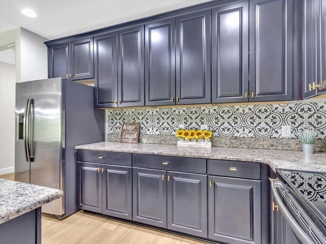 12428 Chaya Ct, Spring Hill, FL 34610 - kitchen with stainless steel fridge, light wood finished floors, backsplash, and light stone counters