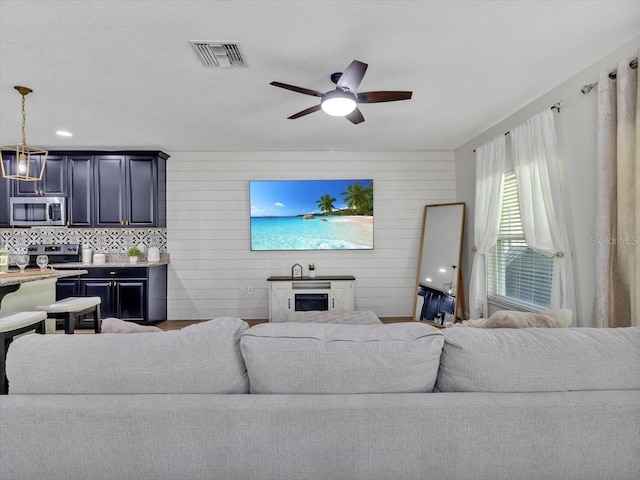 12428 Chaya Ct, Spring Hill, FL 34610 - living room with a ceiling fan, a fireplace, and wooden walls