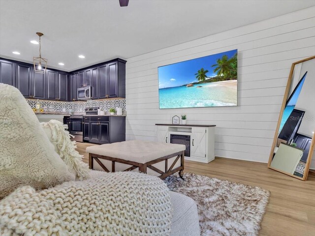 12428 Chaya Ct, Spring Hill, FL 34610 - living room featuring light wood-style flooring, recessed lighting, a fireplace, and wood walls