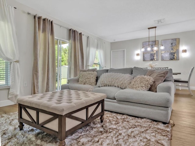 12428 Chaya Ct, Spring Hill, FL 34610 - living room with light wood-type flooring, a chandelier, and baseboards