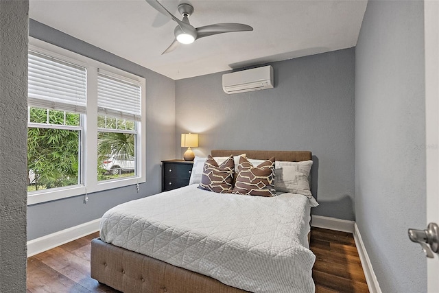 1211 14th St N, Saint Petersburg, FL 33705 - bedroom featuring a wall unit AC, wood finished floors, baseboards, and ceiling fan