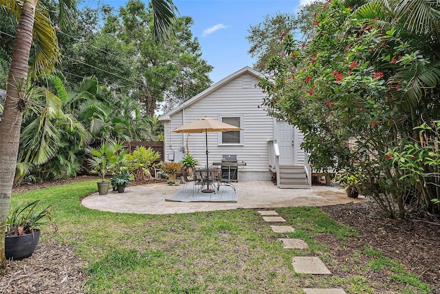 1211 14th St N, Saint Petersburg, FL 33705 - back of house featuring entry steps, a lawn, and a patio