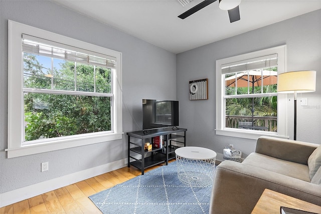 1211 14th St N, Saint Petersburg, FL 33705 - living room featuring healthy amount of natural light, a ceiling fan, wood finished floors, and baseboards