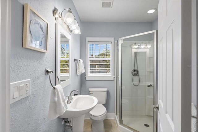 1211 14th St N, Saint Petersburg, FL 33705 - bathroom with toilet, a shower stall, a textured wall, and tile patterned floors