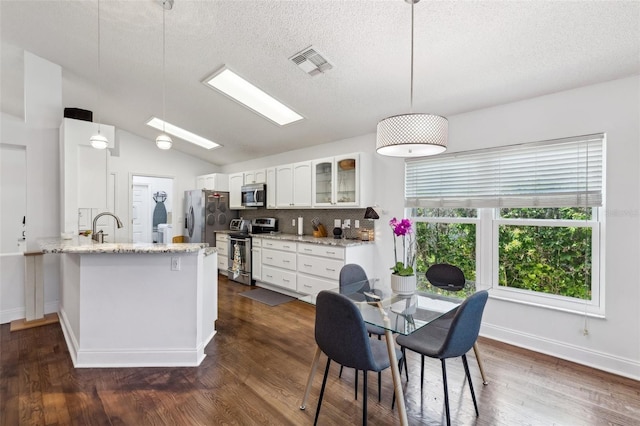 892 Crestridge Cir, Tarpon Springs, FL 34688 - dining area featuring dark wood-style flooring, vaulted ceiling, a textured ceiling, and baseboards