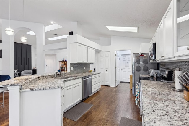 892 Crestridge Cir, Tarpon Springs, FL 34688 - kitchen with a sink, stainless steel appliances, vaulted ceiling, a breakfast bar, and white cabinetry