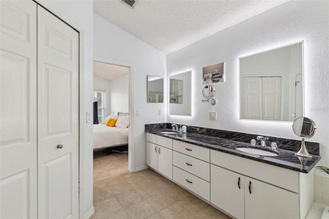 892 Crestridge Cir, Tarpon Springs, FL 34688 - bathroom with vaulted ceiling, double vanity, ensuite bath, a textured ceiling, and tile patterned flooring