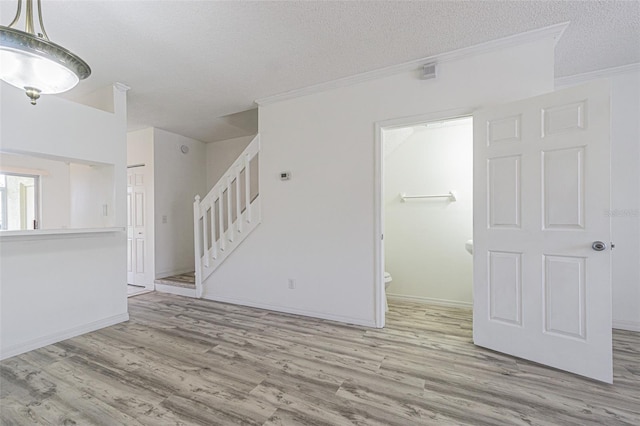 6229 Bayside Key Dr, Tampa, FL 33615 - empty room with stairway, wood finished floors, ornamental molding, a textured ceiling, and baseboards