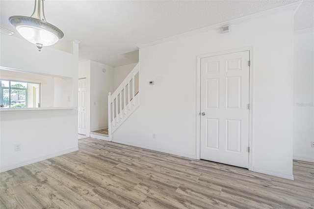 6229 Bayside Key Dr, Tampa, FL 33615 - spare room with wood finished floors, stairs, crown molding, baseboards, and a textured ceiling