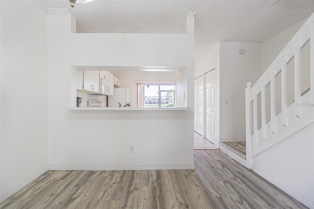 6229 Bayside Key Dr, Tampa, FL 33615 - foyer with light wood-style flooring, baseboards, and a textured ceiling