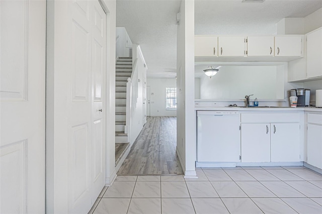 6229 Bayside Key Dr, Tampa, FL 33615 - kitchen with white dishwasher, light countertops, white cabinetry, and a sink