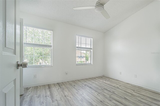6229 Bayside Key Dr, Tampa, FL 33615 - spare room featuring wood finished floors, a textured ceiling, healthy amount of natural light, ceiling fan, and lofted ceiling