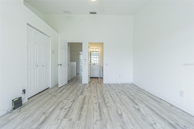 6229 Bayside Key Dr, Tampa, FL 33615 - unfurnished bedroom with light wood-style floors, baseboards, washer / dryer, and ensuite bathroom