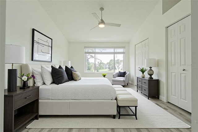 6229 Bayside Key Dr, Tampa, FL 33615 - bedroom featuring light wood-type flooring, multiple closets, baseboards, ceiling fan, and vaulted ceiling