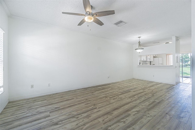 6229 Bayside Key Dr, Tampa, FL 33615 - unfurnished living room with wood finished floors, a textured ceiling, a ceiling fan, baseboards, and ornamental molding