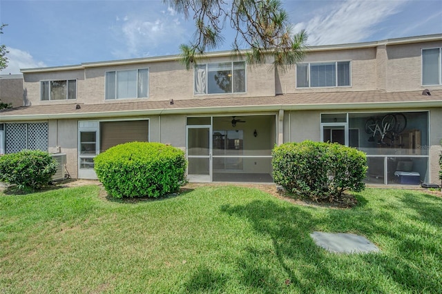 6229 Bayside Key Dr, Tampa, FL 33615 - back of property featuring stucco siding, a lawn, and a sunroom