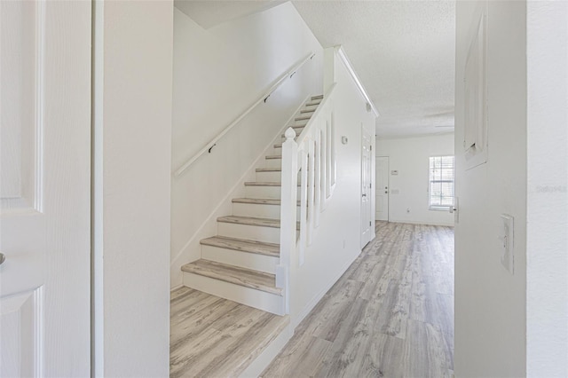 6229 Bayside Key Dr, Tampa, FL 33615 - stairs featuring wood finished floors, a textured ceiling, and baseboards