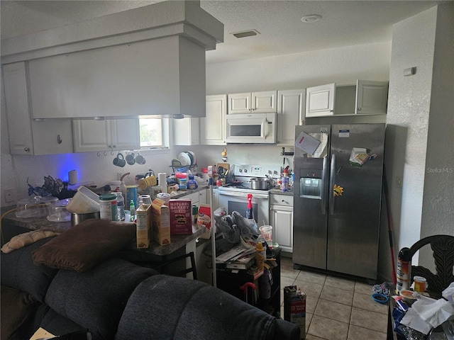 7187 53rd St N, Pinellas Park, FL 33781 - kitchen with white appliances, light tile patterned floors, and white cabinets