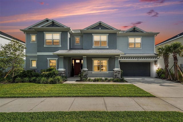 33774 Castaway Loop, Wesley Chapel, FL 33543 - view of front of house featuring covered porch, stucco siding, driveway, a yard, and an attached garage