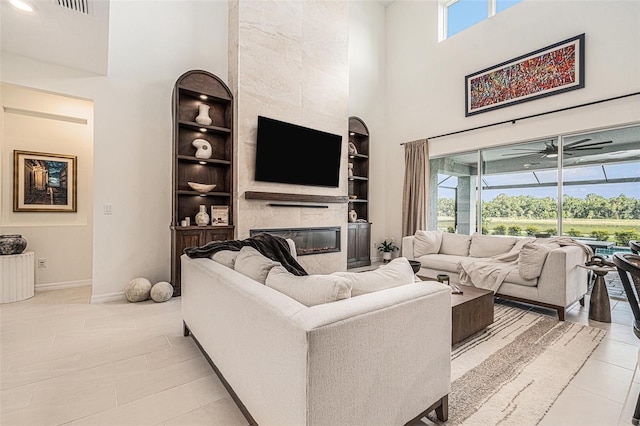 33774 Castaway Loop, Wesley Chapel, FL 33543 - living area featuring a high ceiling, built in shelves, baseboards, a ceiling fan, and light tile patterned flooring