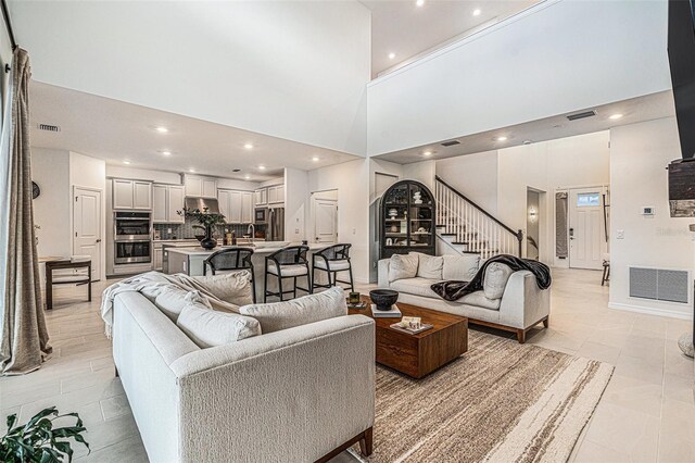 33774 Castaway Loop, Wesley Chapel, FL 33543 - living area featuring stairs, a towering ceiling, recessed lighting, and light tile patterned flooring