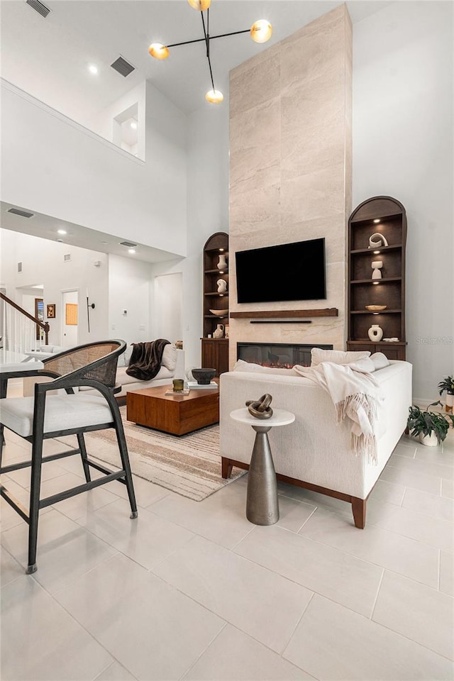 33774 Castaway Loop, Wesley Chapel, FL 33543 - living area with a high ceiling, built in shelves, light tile patterned flooring, and stairs