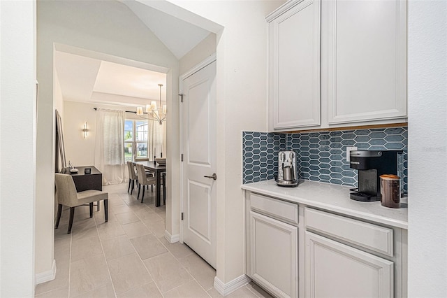 33774 Castaway Loop, Wesley Chapel, FL 33543 - bar featuring a chandelier, backsplash, light tile patterned flooring, and baseboards